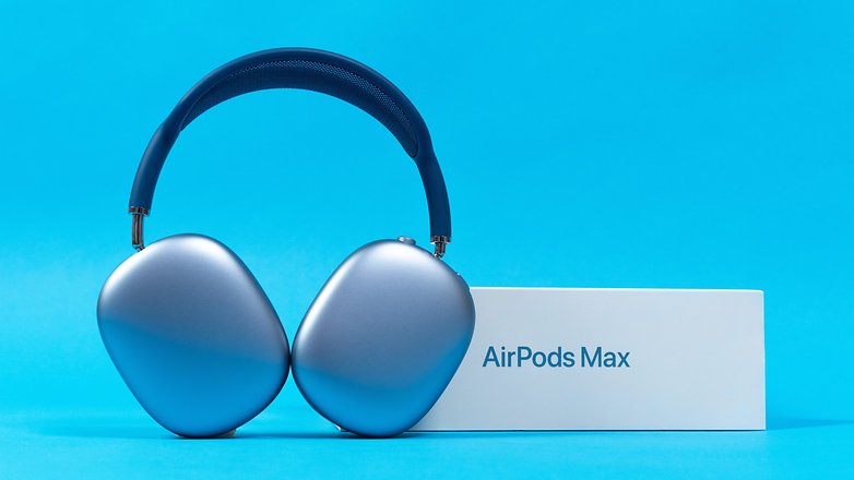 AirPods Max vor blauem Hintergrund und neben der Verpackung