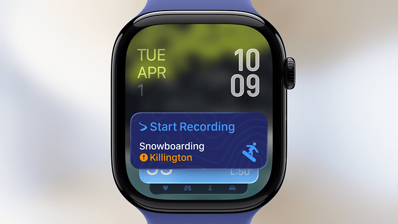 A smartwatch displaying the date, time, and a button to start recording snowboarding at Killington.