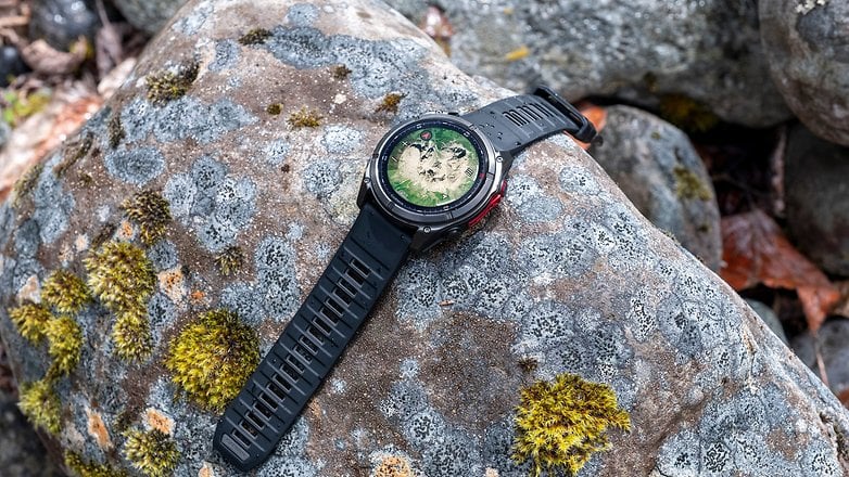 A Garmin watch displayed on a mossy rock in a natural setting. A Garmin watch displayed on a mossy rock in a natural setting.