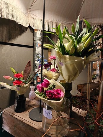 A display of flower bouquets in various colors and types, with a price tag of 10€ on one bouquet.