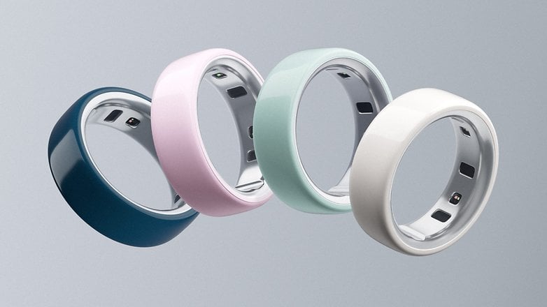 Four Oura Ring 4 devices in different colors: teal, pink, mint, and white, displayed against a gray background.