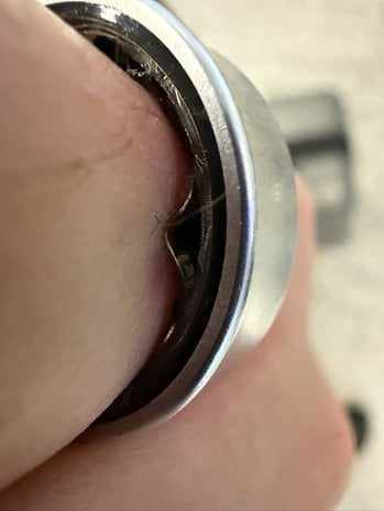 Close-up of a Samsung Galaxy ring on a finger, showing the inner design and texture.