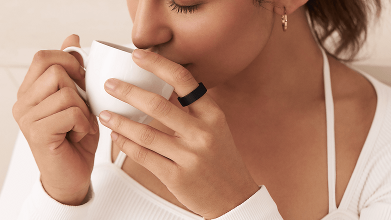 Une personne portant l'anneau ultrahumain Air et buvant un café