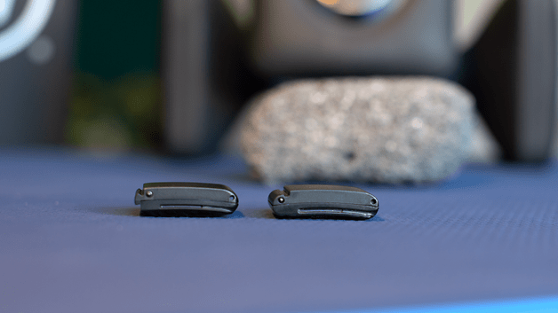 Two Whoop MG sensors placed on a blue surface with a blurred background.