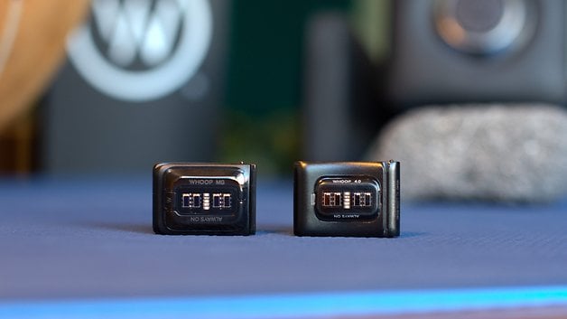 Two Whoop MG sensors displayed on a blue surface with a blurred background.