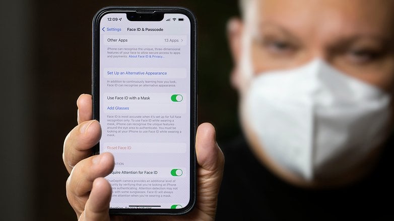 Seseorang yang menunjukkan tetapan Face ID pada paparan iPhone