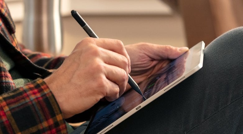 A person using the Zagg Pro Stylus to write something on an iPad