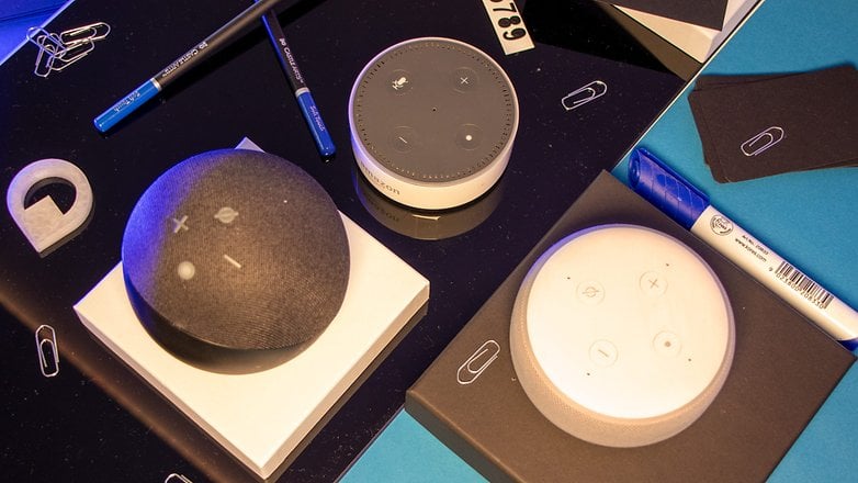 L'Amazon Echo Dot 5 vu du dessus, posée sur une table à côté de précédents modèles d'enceintes Echo Dot