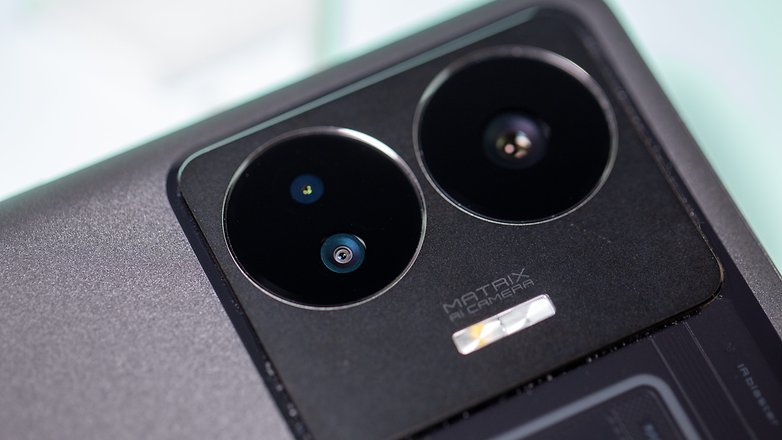 Realme GT 3 camera module up close with three lenses arranged in two circular holes.