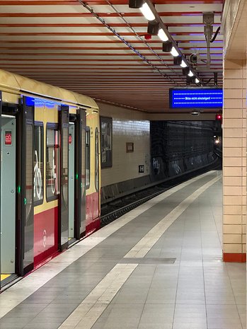 Uma plataforma de metrô com um trem e um sinal dizendo 'Por favor, não embarque!'