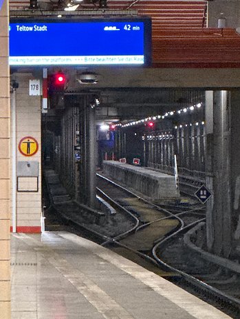 Gare avec un panneau indiquant 'Teltow Stadt' et un compte à rebours de 42 minutes.