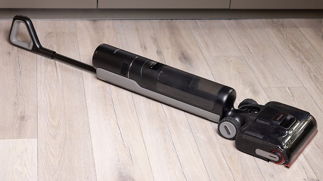 Ein schwarzer und grauer Dreame H15 Pro Staubsauger auf einem Holzboden.