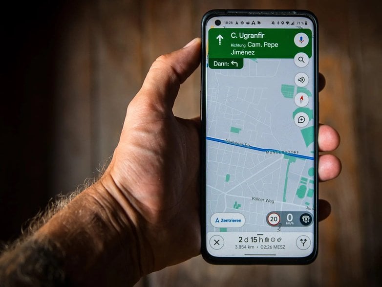 Eine Hand hält ein Smartphone, das Google Maps mit einer Geschwindigkeitsbegrenzung von 20 km/h anzeigt.