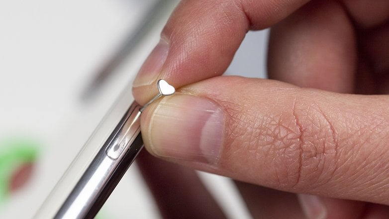 a person opening a SIM slot with an earring