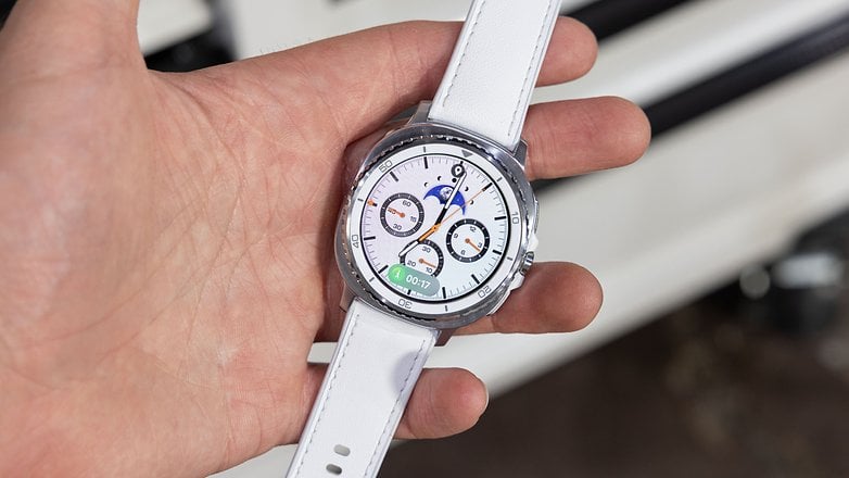 A person holding a Samsung Galaxy Watch 8 Classic with a white strap, displaying various watch faces. A person holding a Samsung Galaxy Watch 8 Classic with a white strap, displaying various watch faces.