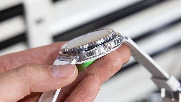 Eine Person hält eine Samsung Galaxy Watch 8 Classic, die ihre seitlichen Tasten und das Design zeigt.