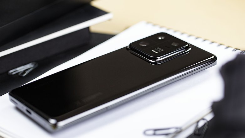 Le Xiaomi 13 Pro posé en diagonale à plat sur un carnet blanc avec son coloris noir au dos