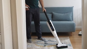 Eine Person saugt einen Teppich mit einem Vorwerk-Staubsauger