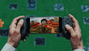 Uma pessoa segura um controlador Backbone com um smartphone exibindo um videogame.