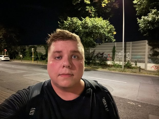 Selfie pris avec l'iPhone 15 Pro Max de nuit avec Antoine portant un t-shirt sombre et un sac à dos dans la rue