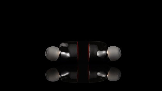 Schwarze In-Ear-Kopfhörer mit weißen Spitzen, auf einem dunklen Hintergrund gespiegelt.