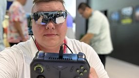 Person mit VR-Brille hält ein Spielgerät auf einer Tech-Veranstaltung.