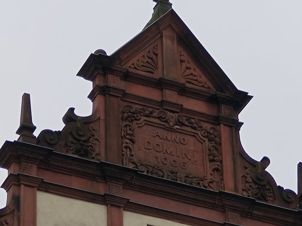 Pignon orné d'un bâtiment avec l'inscription 'ANNO DOMINI 1906' sous un ciel gris.