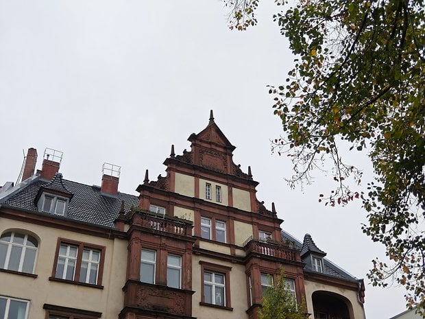 Bâtiment historique avec une architecture complexe, toit en pente et éléments décoratifs.