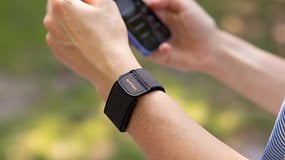 A close-up of a wrist with an Amazfit Helio strap, holding a smartphone.