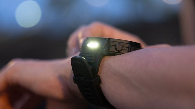 A close-up of an Amazfit T-Rex Pro 3 smartwatch on a wrist, illuminated in low light.