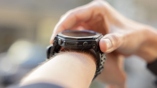 A person adjusting an Amazfit T-Rex Pro 3 smartwatch on their wrist.