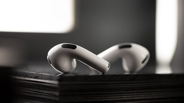 Close-up of Apple AirPods resting on a black surface, showcasing their sleek design.