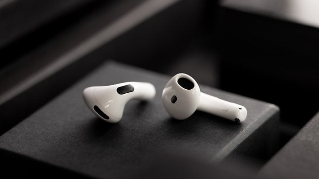 White Apple AirPods on a dark background, showcasing their sleek design.