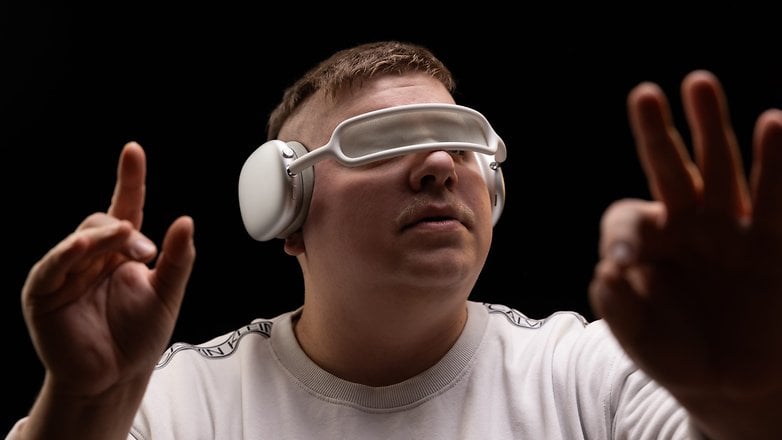 Un homme portant un casque Bluetooth Apple AirPods Max sur ses yeux comme s'il s'agissait d'un casque de réalité virtuelle.