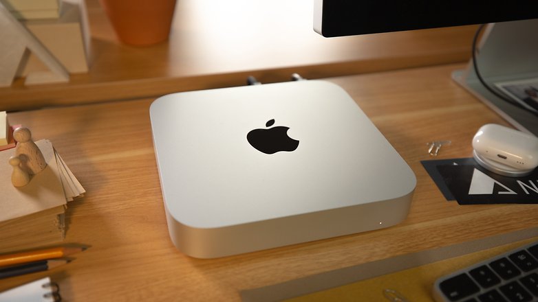 Mac Mini next to an Apple Studio Display and the case of an AirPods Pro