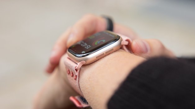 Eine Nahaufnahme einer Apple Watch am Handgelenk, die farbenfrohe Gesundheitsstatistiken anzeigt.