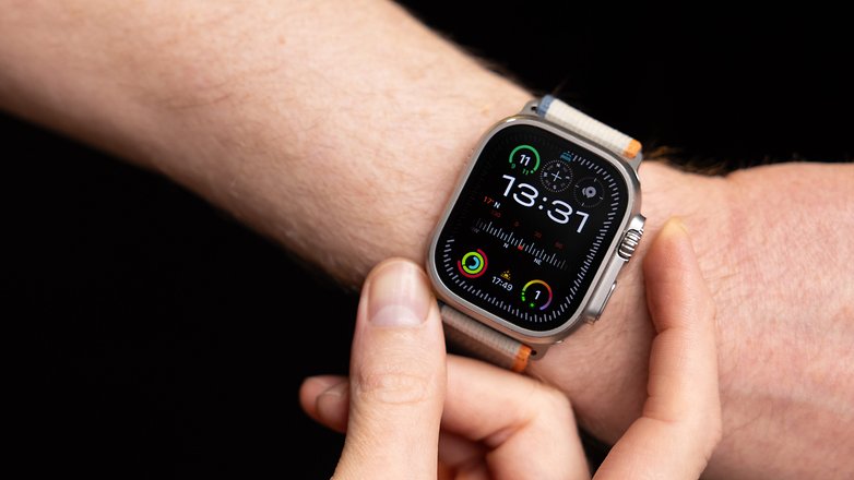 Apple Watch Ultra 2 am Arm, andere Hand betätigt Taste