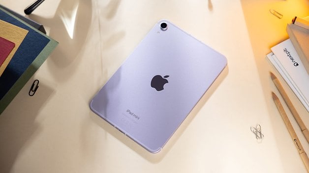 Apple iPad Mini 7 in lilac color, displayed on a desk with stationery items.