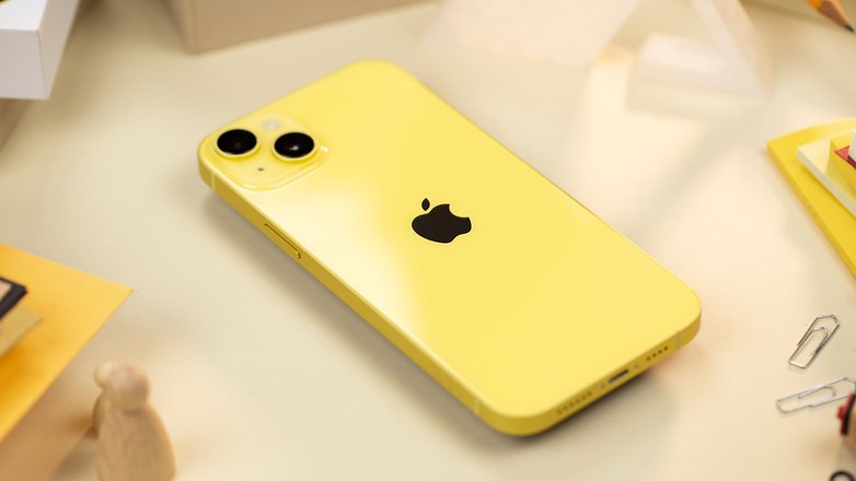 iPhone 14 jaune posé à plat sur une table et vu de dos