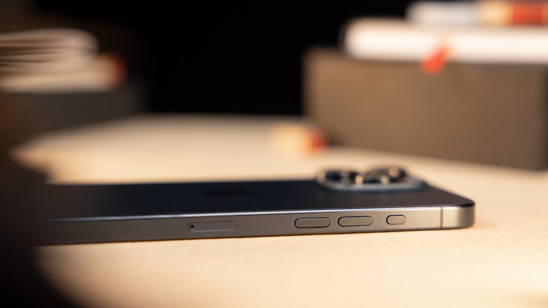 L'iPhone 15 Pro Max vu de côté et posé à plat face contre terre sur une table