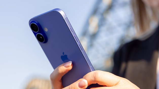 Une personne tenant un iPhone bleu, montrant son double module photo et le logo Apple.