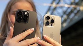 Deux iPhones tenus par une personne, l'un en noir et l'autre en argent, avec un arrière-plan flou.