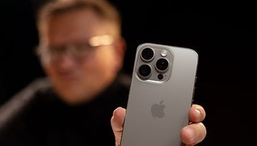 A person holds an Apple iPhone 16 Pro, showcasing its back design with three camera lenses.