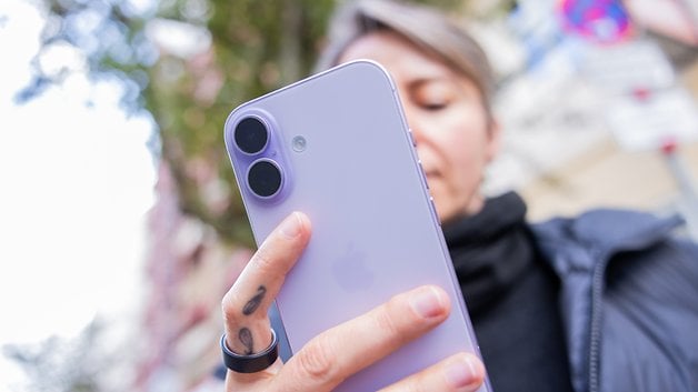 A person holding a purple Apple iPhone 17, focusing on its camera features.