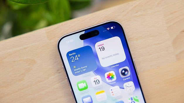 Close-up of an Apple iPhone 17 displaying the weather and calendar on the screen.