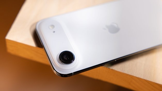 Nahaufnahme eines Apple iPhone Air, das auf einer Holzoberfläche liegt und die Kamera und das Logo zeigt.