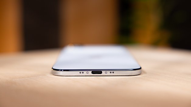 Nahaufnahme der Unterkante eines Apple iPhones mit Ladeanschluss und Lautsprecheröffnungen.