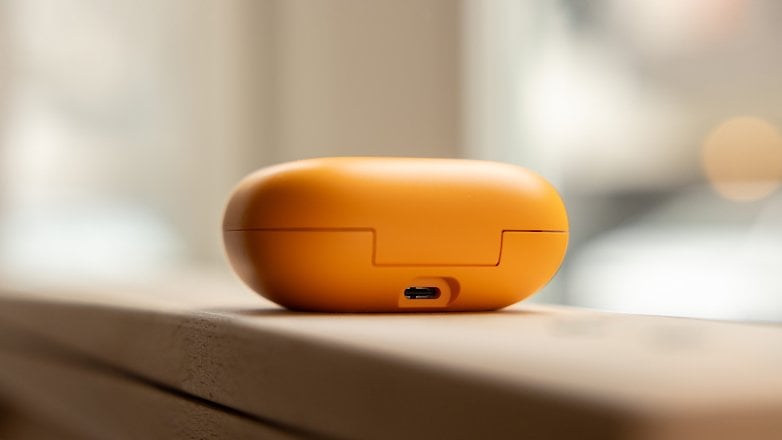 Close-up of yellow Beats Powerbeats Pro 2 charging case on a wooden surface.