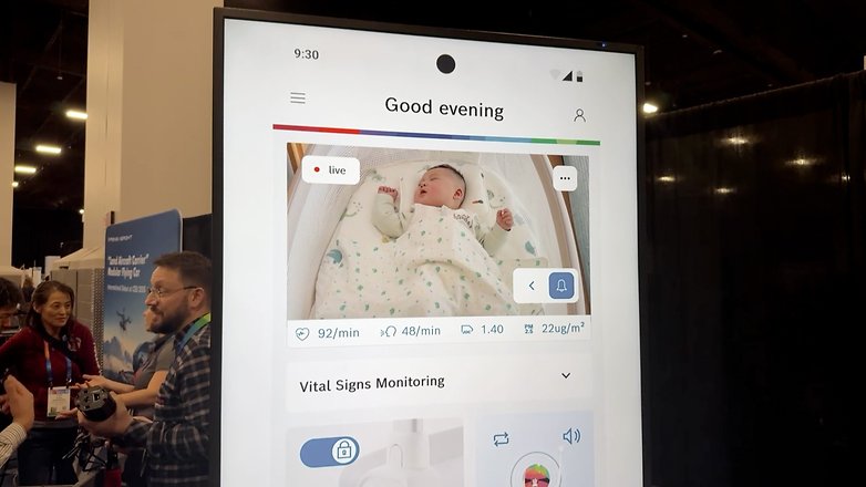 Ein Bildschirm zeigt eine Baby-Monitor-App mit einem schlafenden Baby und Vitalzeichenmetriken.