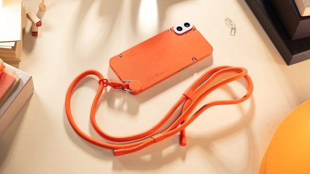 The CMF Phone 1 placed flat on a table and seen from behind with its attached lanyard.